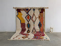 Vibrant moroccan handmade traditional azilal rug with geometric patterns in cream yellow red blue and orange by decorbites