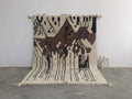 Beige and brown geometric-patterned moroccan handmade traditional azilal rug with black accents and fringed edges by DecorBites