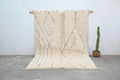 Cream-colored moroccan handmade beni ouarain rug with geometric darker beige patterns and fringed handwoven edges 283 x 211 cm