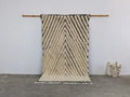 Cream-colored textured wool beni ouarain rug with bold black zigzag stripes and fringed edges moroccan handmade