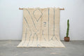 Cream-colored moroccan handmade beni ouarain rug with muted blue geometric patterns and fringed woolen texture 300 x 205 cm