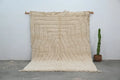 Cream-colored thickly textured wool beni ouarain rug with geometric concentric wavy lines and fringed edges moroccan handmade