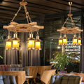 Decorbites™ noemi industrial pendant chandelier with rustic wood spool and brass lanterns with warm yellow lighting