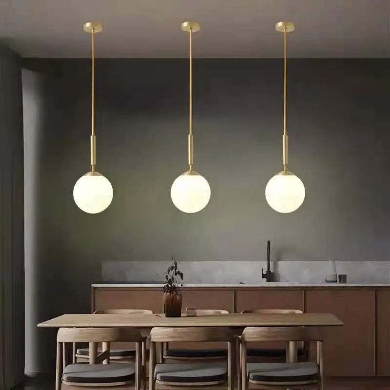 DecorBites™ nordic glass ball pendant light with gold-finished rods and frosted glass shades above dining table