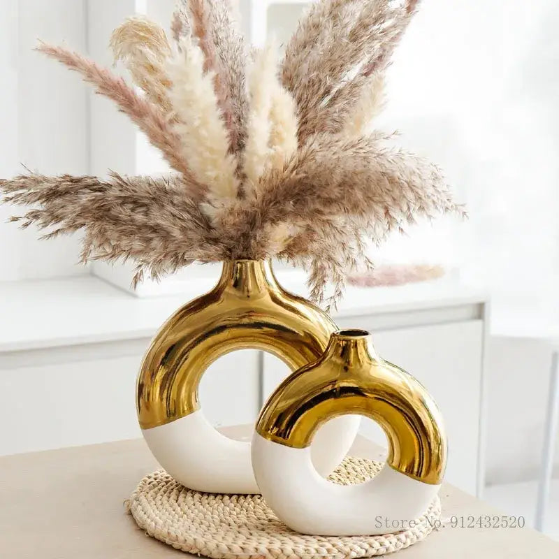 Two modern ceramic nordic style circle vases in glossy gold and white for elegant flower arrangement by DecorBites™