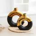 Two sleek modern ceramic nordic style circle vases in bold black and gold for flower arrangement by decorbites