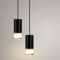 Two sleek black cylindrical decorbites plug-in hanging lights with frosted glass bases hang from thin cords