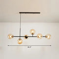 Modern black metal chandelier with six warm-toned glass globe bulbs for dining rooms in grey blue white decor settings