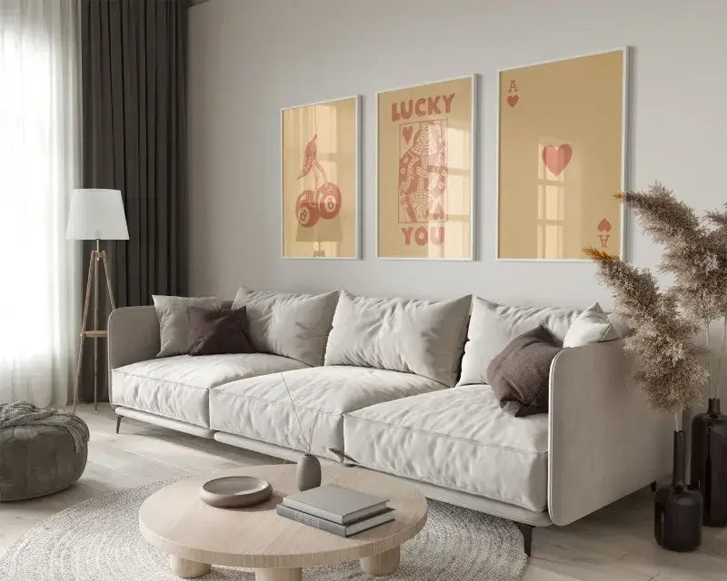 Light gray upholstered sectional sofa with dark brown throw pillows featured alongside DecorBites™ retro queen of hearts wall art posters