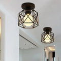 Decorbites™ semi flush mount light with black geometric metal frame and warm glowing bulb inside for indoor use