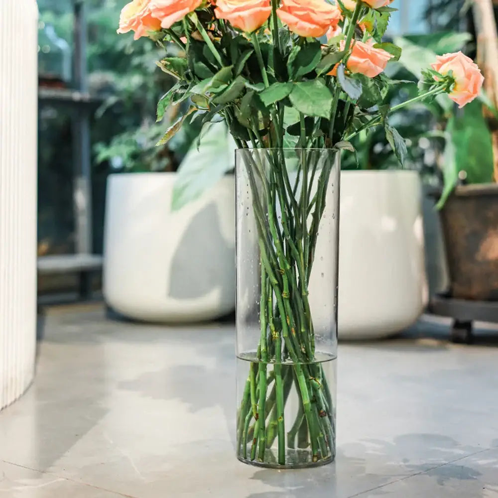 DecorBites™ shatterproof clear acrylic cylinder vase holding peach-colored roses in a clear acrylic cylinder design