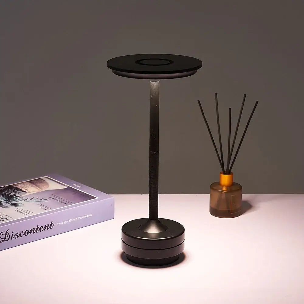 Modern black minimalist desk lamp with simple charging led and adjustable circular light head for versatile use