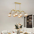 DecorBites sleek gold spiral island light with five glass bulbs on curved metal arms in a gold finish