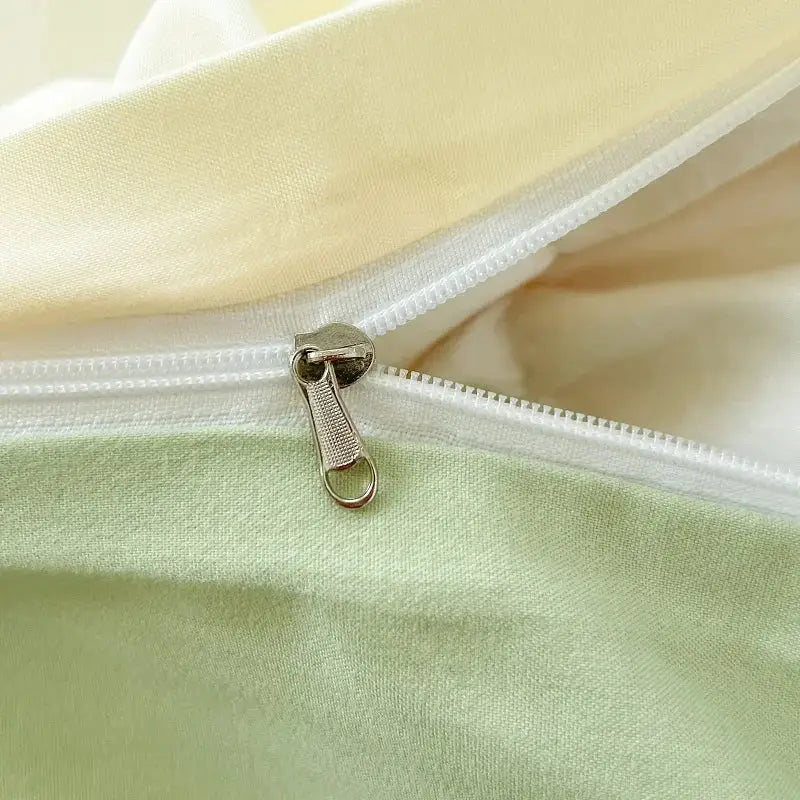 Silver-toned zipper pull with textured grip on decorbites™ solid color brush fabric duvet cover set in light green and cream