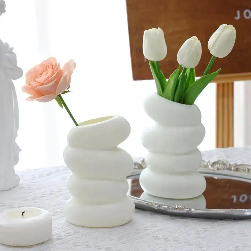 White ceramic spiral white vase with stacked rounded segments holding white tulips for home decor by DecorBites