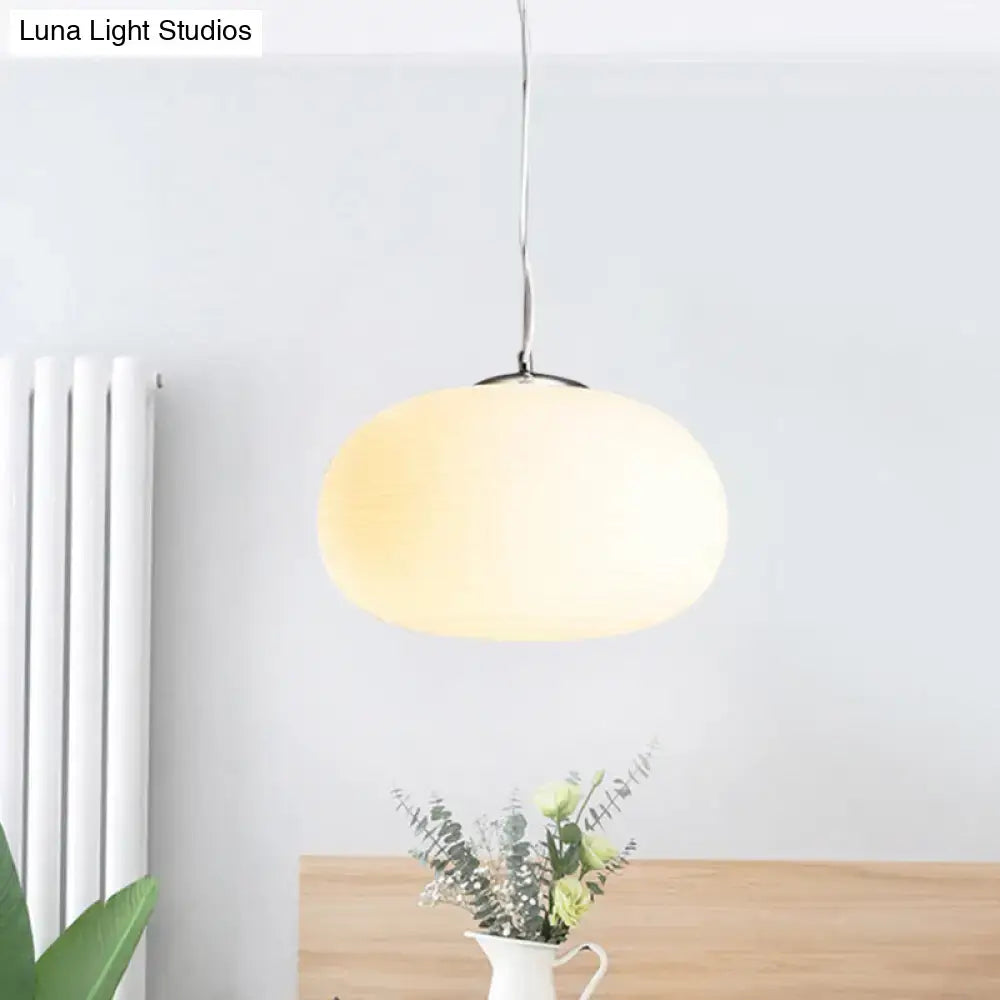 A sleek nordica pendant light with oval frosted opal glass shade and polished chrome, ideal for office and kitchen island lighting