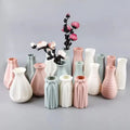 A collection of pastel-colored ceramic vases with geometric designs holding dried flowers for stylish home decor