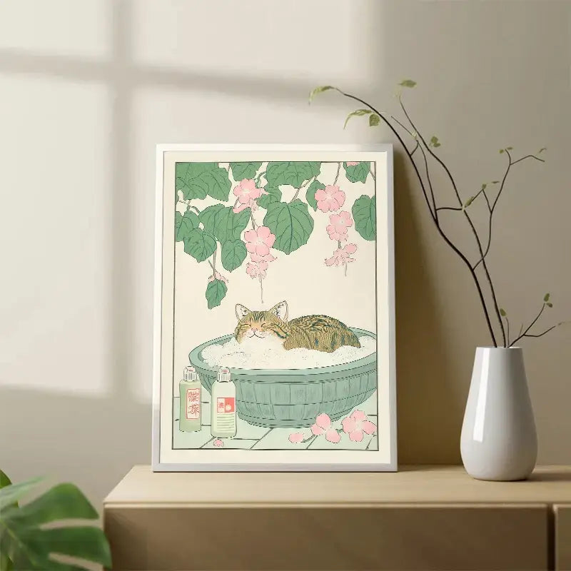 A framed canvas wall art of a tabby cat lounging in a green basin with foam and pink blossoms by DecorBites™