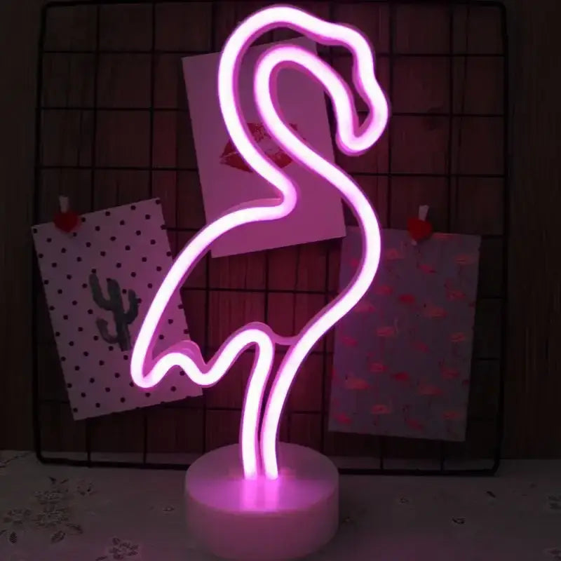 A glowing pink neon sign led lamp shaped like a flamingo with a white circular base for holiday decoration