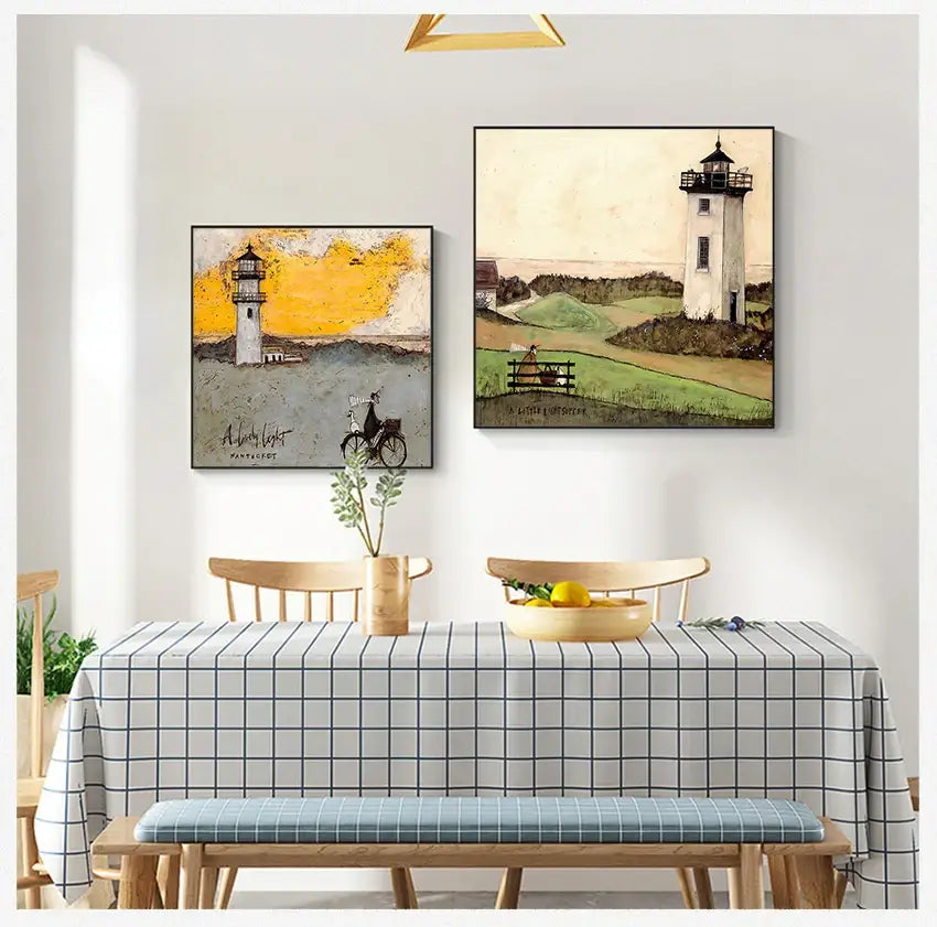Two framed vintage nordic abstract landscape lighthouse paintings hang above a dining table in a living space