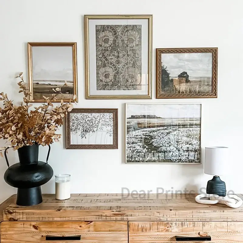 Set of five framed black and white vintage summer landscape oil painting prints with ornate gold frames above console table