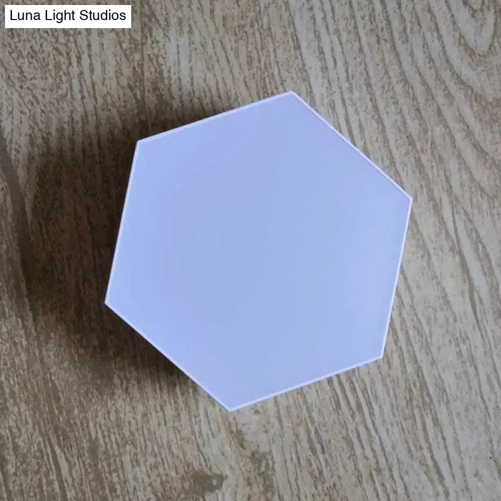 A sleek matte lavender geometric hexagon led wall light with bluetooth app control for bedroom use