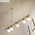 Gold-toned metal linear island pendant light with four exposed globe bulbs for dining room lighting