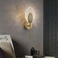 Gold-toned led wall lamp with textured oval glass diffuser and intricate metal backplate for indoor lighting