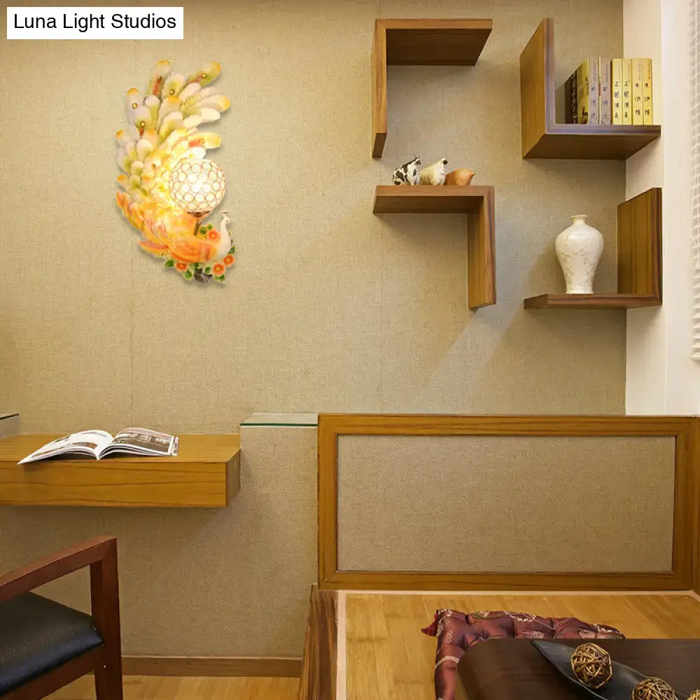 Golden peacock wall light with crystal shade – living room yellow & green