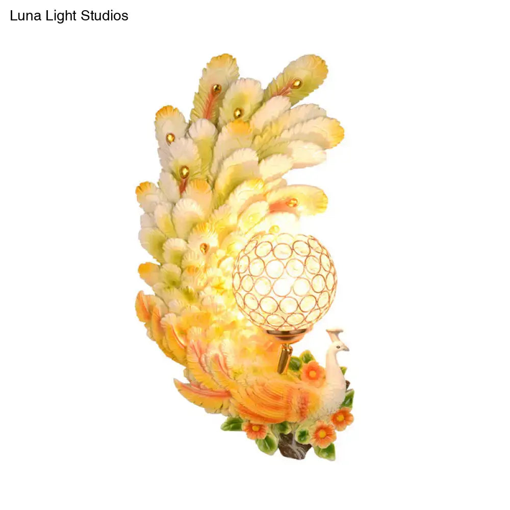 Golden peacock wall light with crystal shade – living room yellow & green