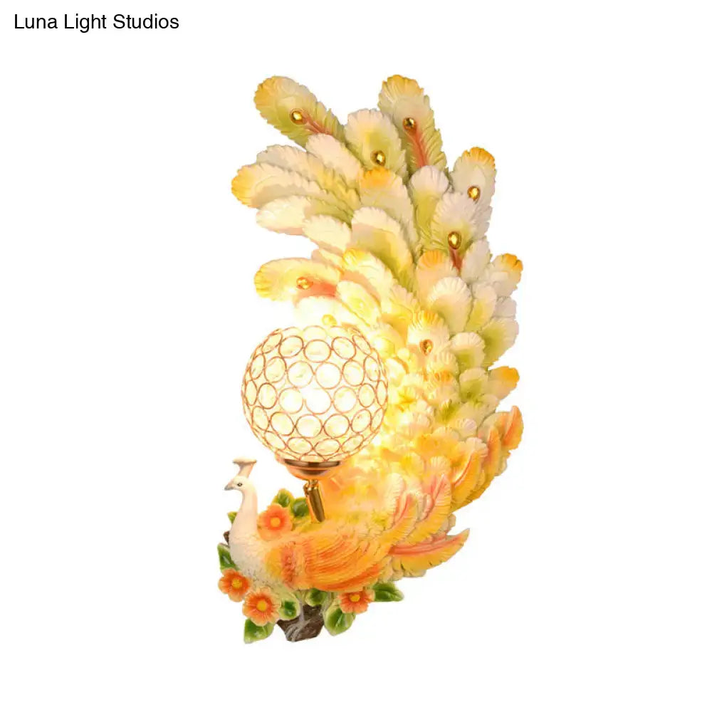 Golden peacock wall light with crystal shade – living room yellow & green