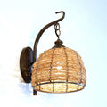 Handmade asian rattan dome wall sconce with brown rattan weave and dark bronze metal arm fixture type wall lamp