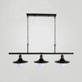 Black industrial-style metal kitchen ceiling light with three exposed bulbs and brass accents for flat shade island lighting