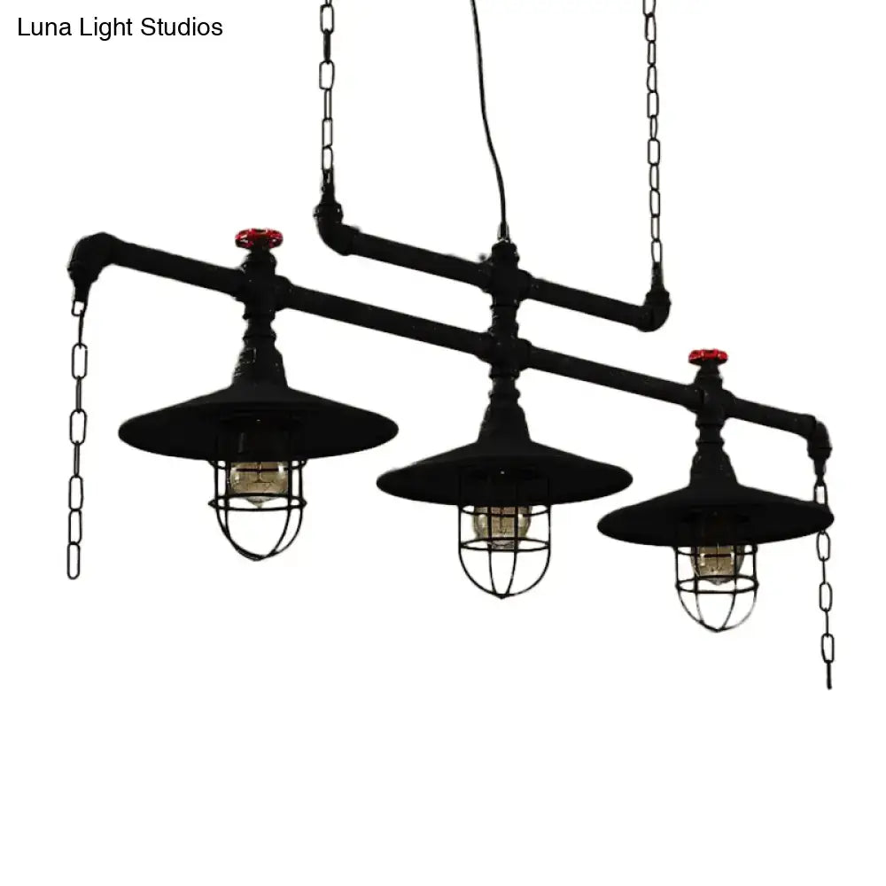 Industrial black pipe chandelier with red valve caps featuring two exposed bulbs and protective wire cages for dining room lighting