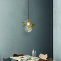 Industrial glass and wood pendant light kit with exposed bulb and green plant stems for dining room illumination