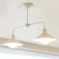 White industrial-style DecorBites pendant light with two conical shades and curved angle arm for kitchen island lighting