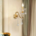 Mid-century brass crystal shade wall mounted sconce with gold-toned curved arm and clear faceted crystals for bedroom lighting
