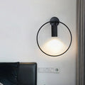 Minimalist black circular metal sconce with frosted glass diffuser for living room wall lighting