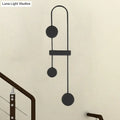 Black gold minimalist metal led wall sconce with sleek curved arms and three circular discs for bedroom lighting