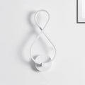 White infinity-shaped acrylic led wall lamp with sleek minimalist black and white design for bedroom sconce lighting