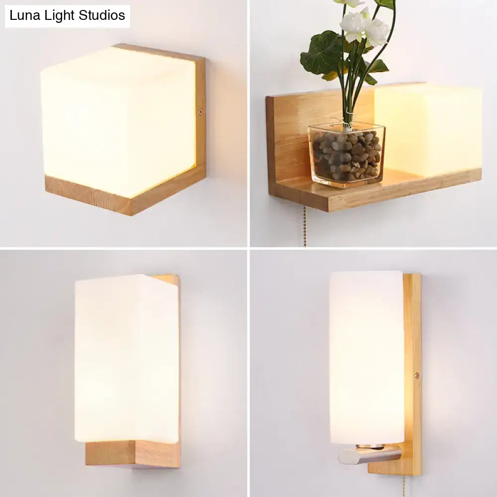 Minimalist brass and glass geometric wall sconce with warm diffused light and frosted glass shade on light wood frame