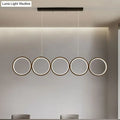Modern black minimalist metallic led suspension lamp with five illuminated circular rings providing warm white light