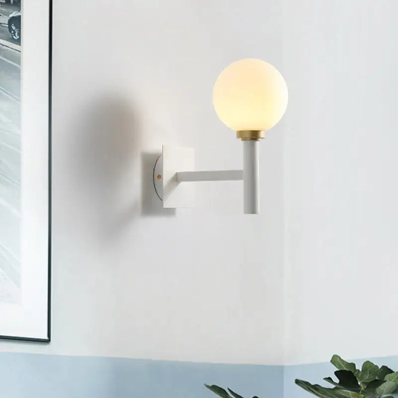 Minimalist white and brass wall lamp with opal glass shade bedroom