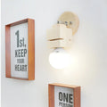 Minimalist wood wall lamp with light wood circular backplate and off-white wooden blocks supporting led bulb 110v-240v