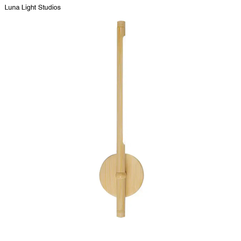 Minimalist yellow bamboo wall mounted sconce with circular base and slender stem providing warm white natural light