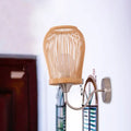 Beige bamboo cage wall sconce with metal gooseneck arm and circular mounting plate for modern bedroom lighting