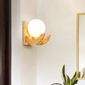 Modern beige wood sconce light fixture with frosted white globe and curved wood arms wall lamp for bedroom use