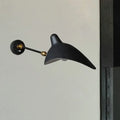 Modern black and brass wall lamp with metallic shade and sleek curved duckbill design for living room fixture height
