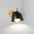 Modern black and brass metal wall light bedroom sconce with adjustable arm wood backplate and brass interior