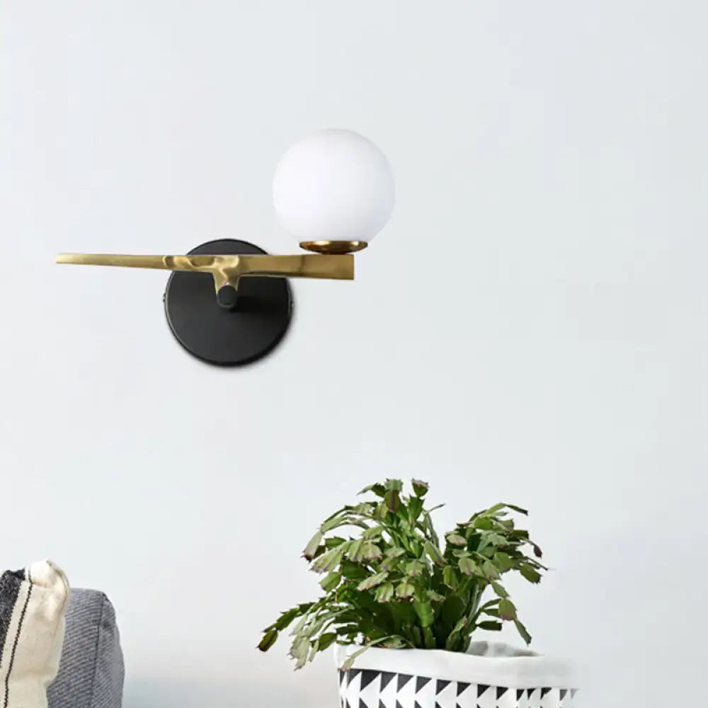 Modern black and brass wall sconce with white glass ball shade bedroom